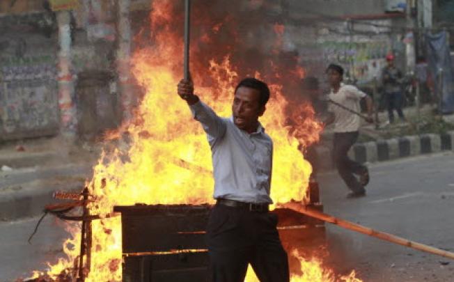 An activist of Jamaat-e-Islami gestures to the police during a clash in Dhaka. Police in Bangladesh’s capital clashed with protesters again on Tuesday. Photo: Reuters
