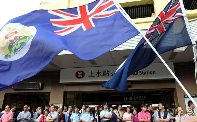 Protestors wave Hong Kong colonial flags outside Sheung Shui MTR station. 