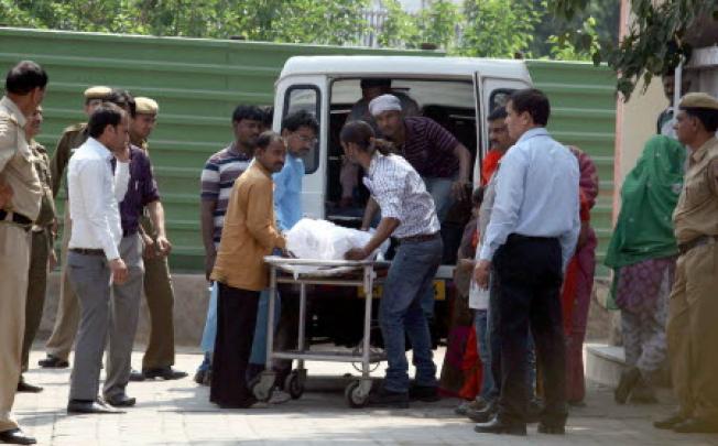Relatives of Ram Singh, one of the six men accused of raping a student on a bus and found dead in Tihar Jail, transfer his body to an ambulance in New Delhi. Photo: Xinhua