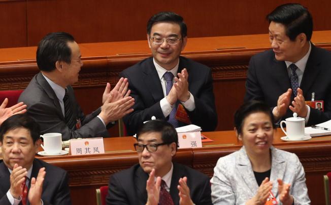 Zhou Qiang (centre, back row) is congratulated by other deputies after being elected president of the Supreme People's Court at the National People's Congress. Photo: Xinhua