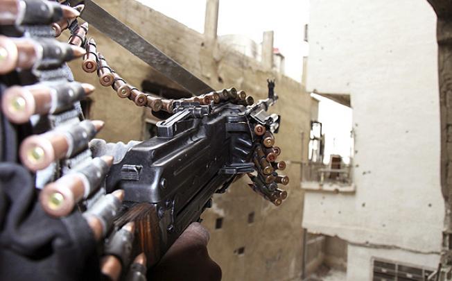 A Free Syrian Army fighter guards the front line in the Sidi Meqdad suburb of Damascus. Photo: Reuters