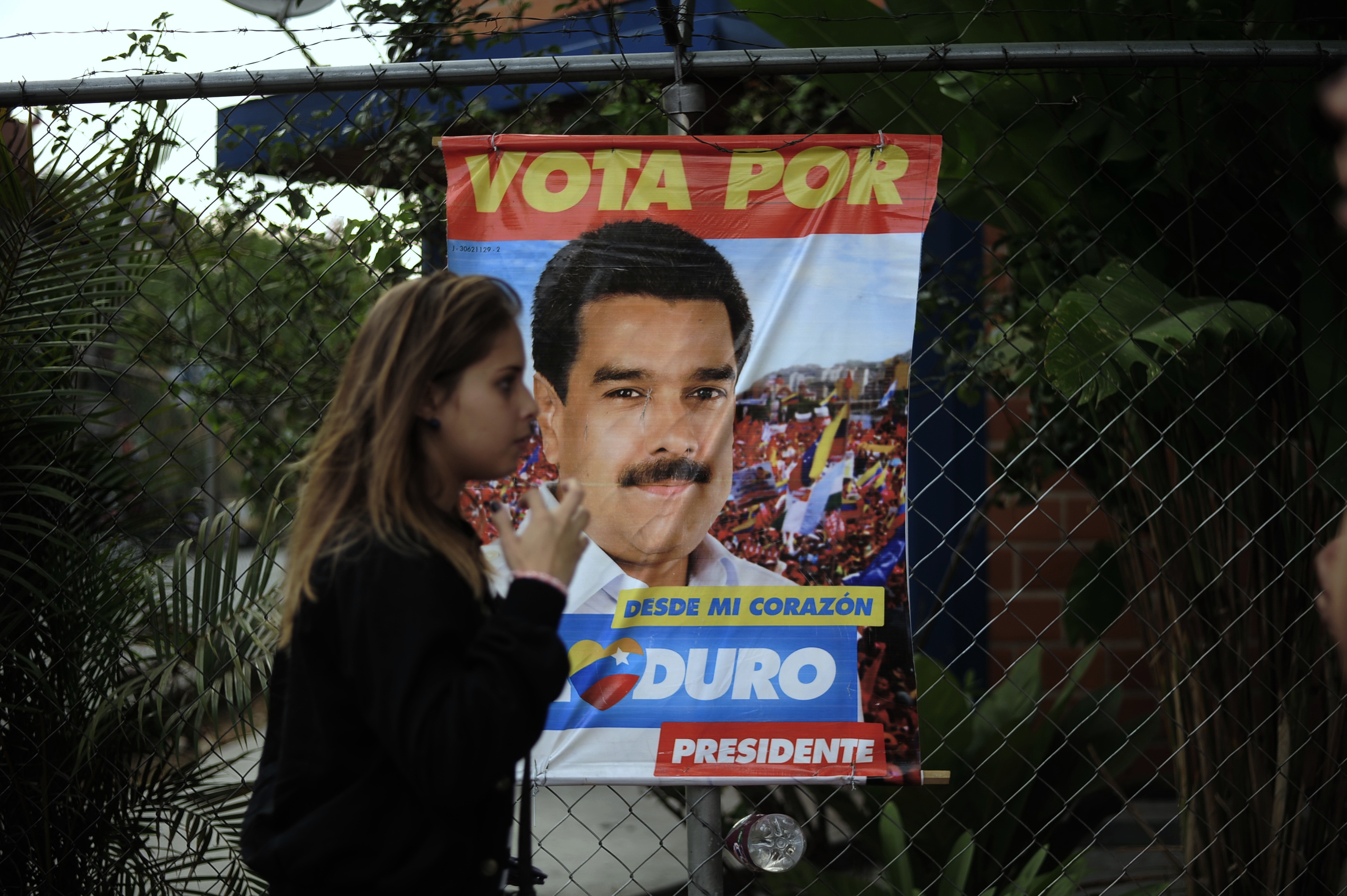 A woman walks past an electoral poster of Venezuela's Acting President and presidential candidate Nicolas Maduro in Caracas. Photo: Xinhua