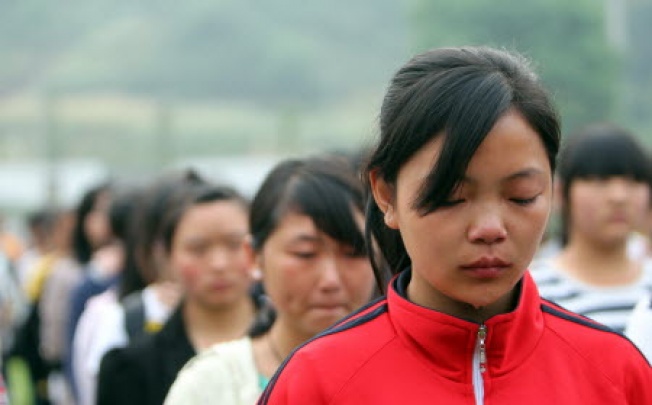 A girl sheds tears as students at Lushan Middle School in Lushan county take part in a public mourning ceremony yesterday in memory of those who perished in the magnitude 7 earthquake that hit the area in the southwestern province of Sichuan eight days ago. Nearly 200 lives were lost. Photo: Xinhua
