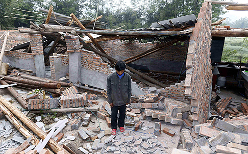 A resident stands among the Yaan quake ruins. Photo: AFP