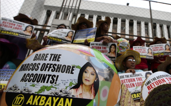 Protesters holding banners bearing the face of Ferdinand and Imelda Marcos' daughter Imee demand action on the former first family's offshore accounts during a protest in Manila on April 8. Photos: AFP; AP; Reuters