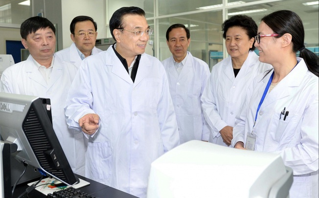 Premier Li Keqiang visits a disease control unit at the centre of efforts to curb the spread of the H7N9 virus (left). Photo: Xinhua