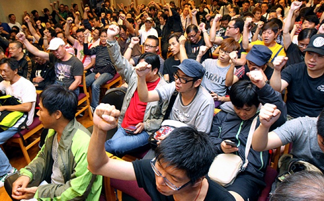 Hundreds of striking dock workers vote in favour of accepting the pay offer at a meeting in Wan Chai yesterday. Photo: David Wong