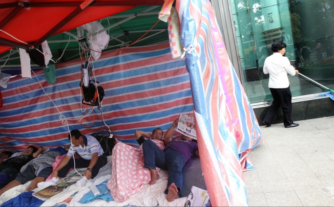 A small group still camps out at the Cheung Kong Center in Central yesterday. Photo: David Wong