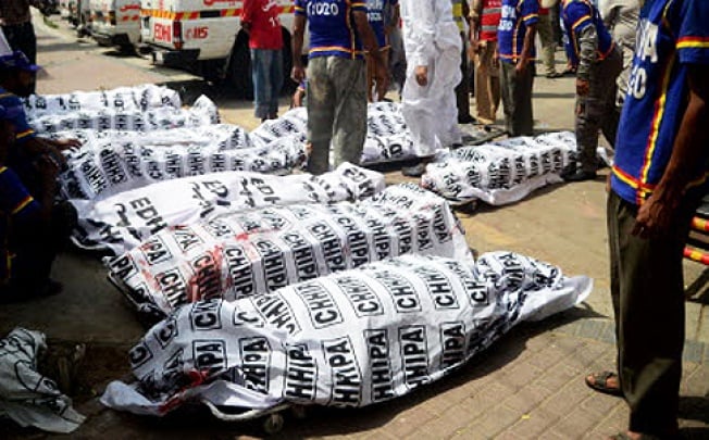 Pakistani volunteers gather beside the dead bodies of blast victims outside a hospital following a bomb explosion in Karachi on Saturday. Photo: AFP