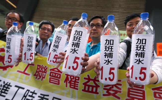 Unionists protest outside where the Standard Working Hours Committee was meeting. Photo: Sam Tsang
