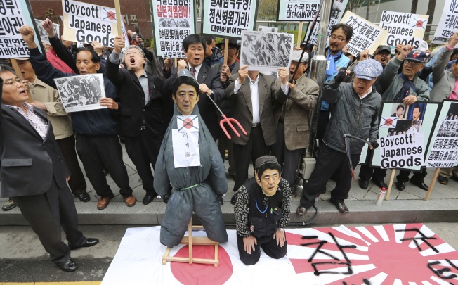 Members from conservative civic organizations with an effigy of Japanese Prime Minister Shinzo Abe shout slogans during a rally to protest Japanese lawmakers who made a visit to Yasukuni Shrine in Tokyo. Photo: AP