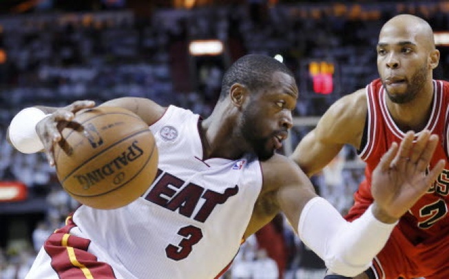 Miami Heat's Dwyane Wade (L) drives past Chicago Bulls' Taj Gibson during the sceond quarter in Game 5 of their NBA Eastern Conference semi-final basketball playoff in Miami, Florida. Photo: Reuters