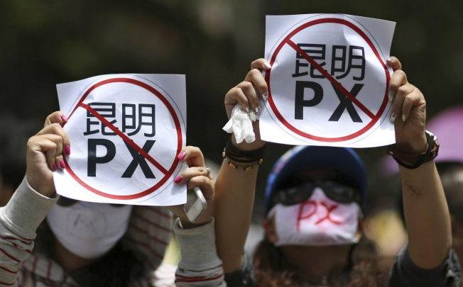 Demonstrators display posters reading "Kunming PX" in a rally against a planned paraxylene plant.