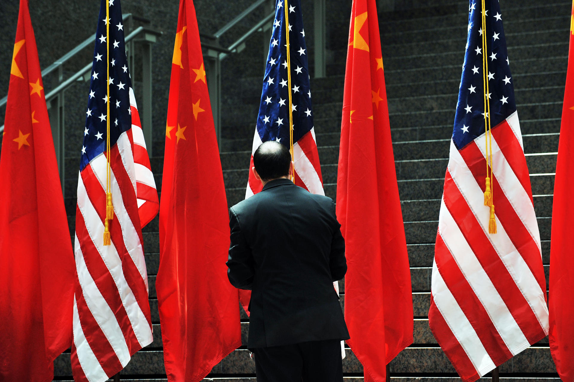 A US official adjusts Chinese and US flags before a trade meeting. China is a top recipient of US student and work visas .Photo: AFP