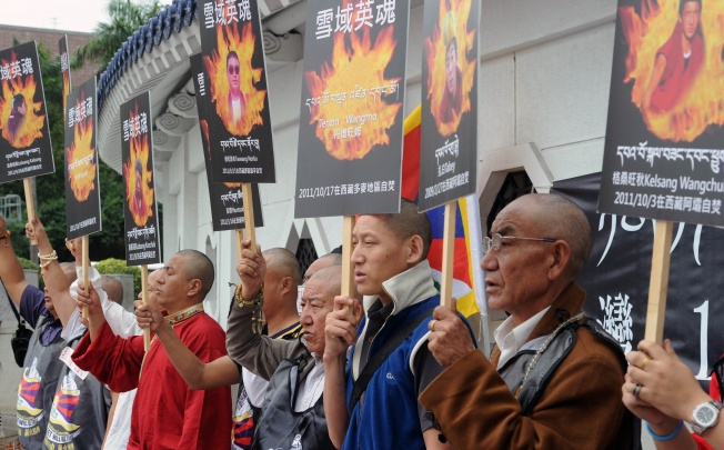 Tibetans display portraits of people who killed themselves in self-immolation, during a protest in front of the Liberty Square in Taipei. Photo: AFP