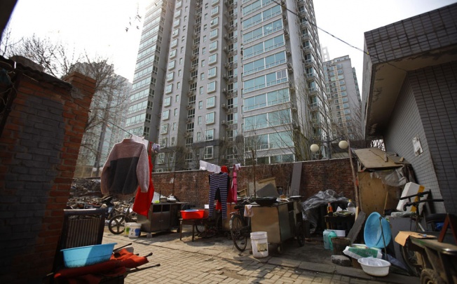 A yard outside migrant workers' makeshift houses is seen next to a city residential compound in central Beijing. Photo: Reuters