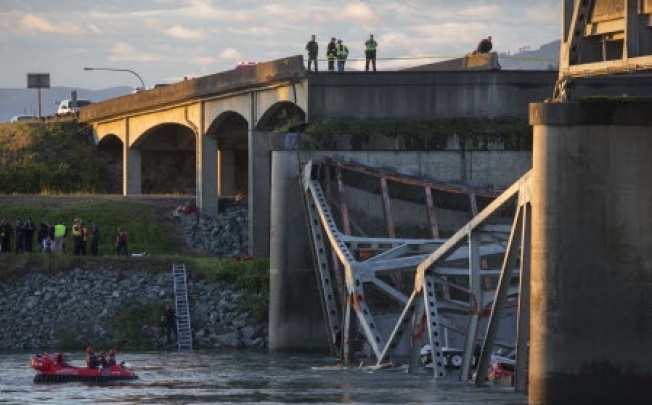 A portion of the Interstate 5 bridge is submerged after it collapsed into the Skagit River dumping vehicles and people into the water as rescuers watch from the collapsed section of Interstate 5 and hovercraft search for survivors below in Mount Vernon, Washington. Photo: AP