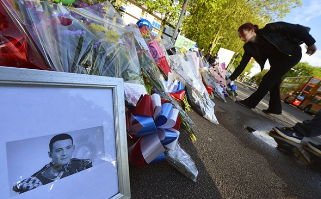 A picture of victim Lee Rigby of the Royal Regiment of Fusiliers is displayed with flowers near the scene of his killing in Woolwich. Photo: Reuters