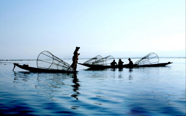 Fishermen set conical traps as they row their boats with their legs on Inle Lake, in Myanmar's Shan State. Photo: Thinkstock