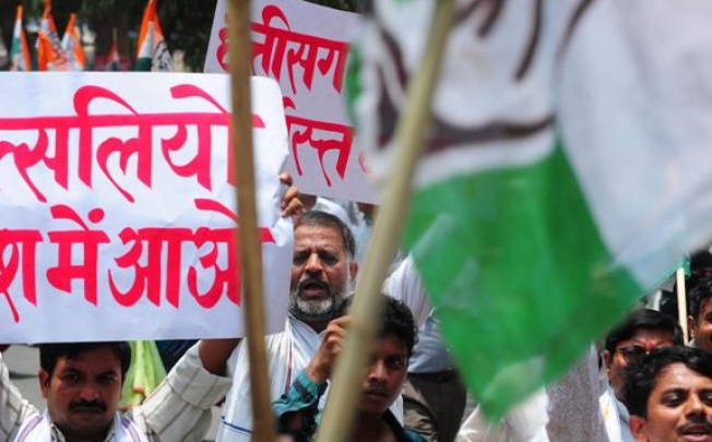 Congress party activists shout slogans and wave placards in Allahabad yesterday in a show of solidarity after the deadly attack on their fellow members on Saturday. Photo: AFP