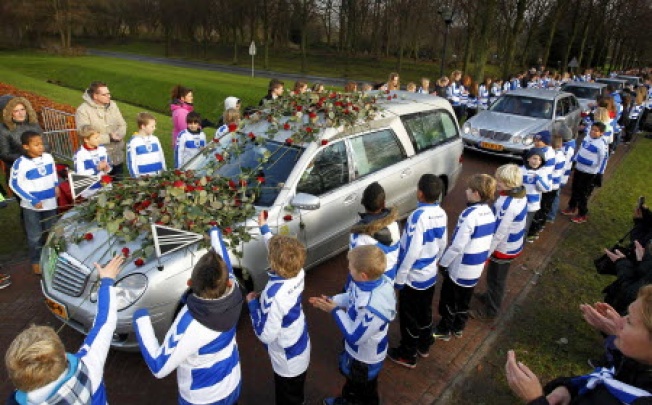 Members of Dutch soccer club SC Buitenboys lay roses on the hearse carrying the body of Richard Nieuwenhuizen at a crematory in Almere, Netherlands, on December 10 2012. Photo: Reuters