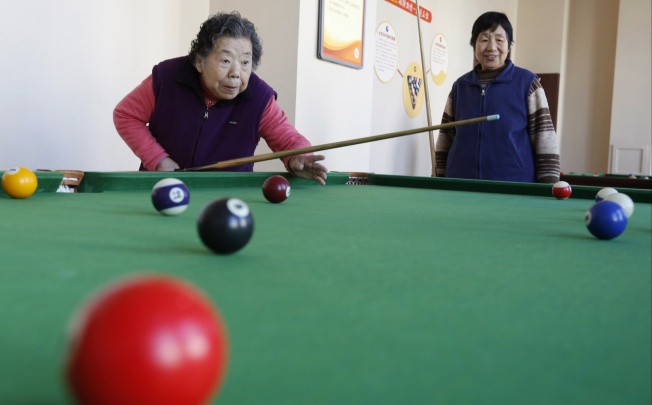 Residents of a nursing home in Beijing play billiards during their recreational time on March 1, 2013. Photo: Reuters