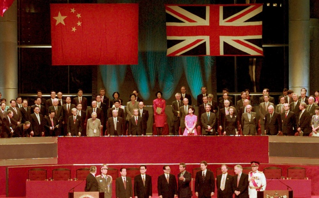 Leaders of China and Britain stand to attention following the hoisting of the Chinese flags at the handover ceremony minutes after midnight of July 1. Photo: Reuters