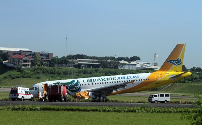 A Cebu Pacific Airbus A320 plane sits on the grassy part of the runway at the international airport in Davao, after it overshot the runway. Photo: AFP