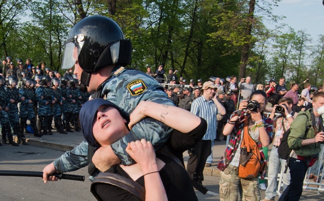 A Russian policeman detains protester Alexandra Dukhanina during a rally in Moscow. Dukhanina is one of 12 Russians to go on trial in Moscow on Thursday accused of violence at a protest against President Vladimir Putin last year. Photo: AP 