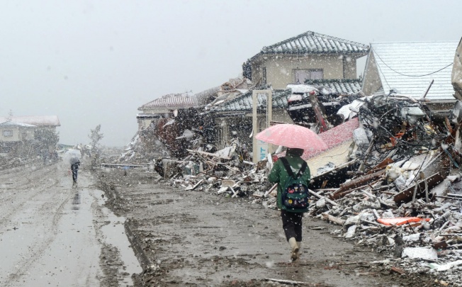 Survivors walk amid the real devastation caused by the Tohoku disaster in Natori, Miagi Prefecture, just a few days after the earthquake and tsunami. Photo: AFP