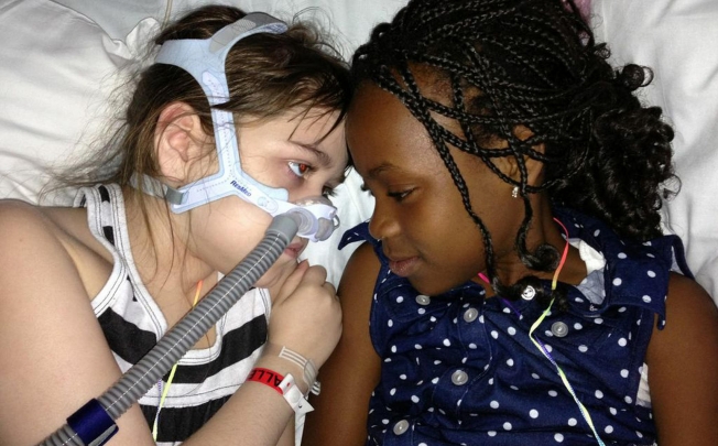 Sarah Murnaghan (left) lies in her hospital bed next to adopted sister Ellas. A genetic disease has ravaged her lungs. Photo: AP