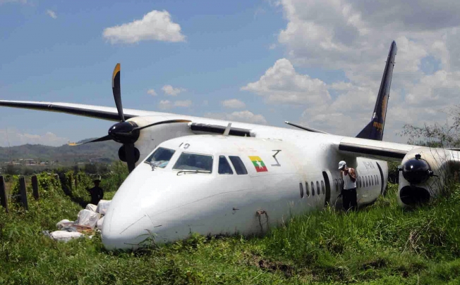 Rescuers and officials inspect the damaged Chinese-made Xian MA60 turboprop that overshot the end of the runway in Monghsat, in Shan State, May 2013. Photo: AFP