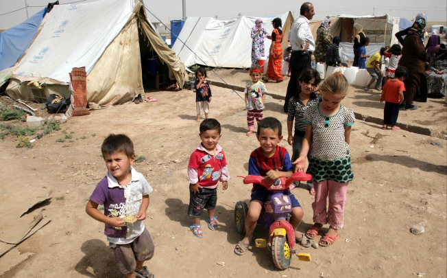 Syrian-Kurdish children refugee play outside tents at the Domiz refugee camp, 20 km southeast of the northern Iraqi city of Dohuk. Photo: AFP