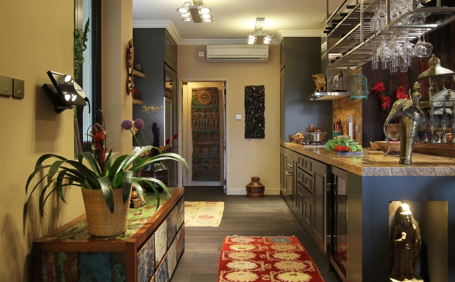 Kitchen: The cabinetry and countertops in the kitchen and the stainless-steel glass rack were custom made by Loft Square Interior Design (4/F, Block A, Alexandra Industrial Building, 1064 Tung Chau West Street, Lai Chi Kok, tel: 9497 9125). The chest, made from recycled boat wood, and the rugs, were all bought from Shambala (2/F, Horizon Plaza, 2 Lee Wing Street, Ap Lei Chau, tel: 2555 2997). Protruding from the wall is the control panel for a Bang & Olufsen sound system.
