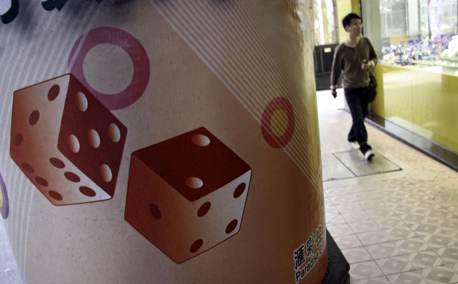 A pedestrian walks by an ad for a casino in Macau, where a Nevada gaming official says money laundering is rife. Photo: Bloomberg