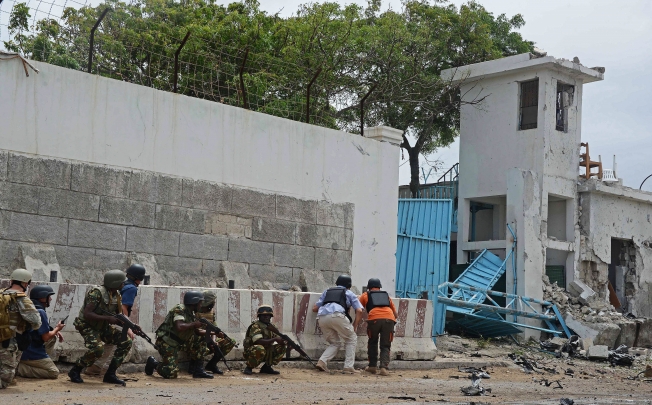 Amisom troops take cover after al-Qaeda linked al-Shabab insurgents blasted their way into the UN compound in Mogadishu on June 19. Photo: AFP