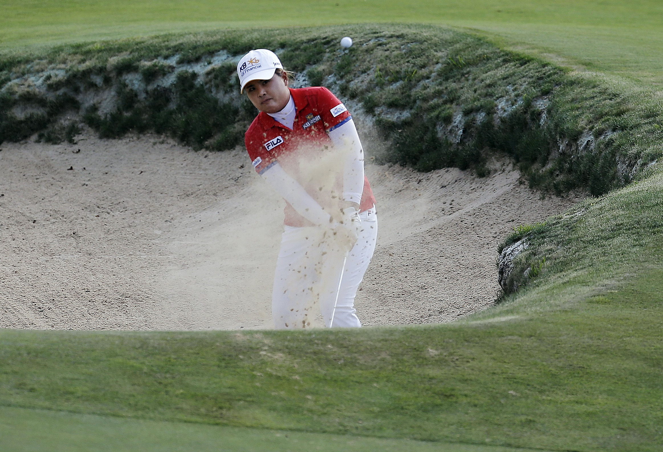 Park In-bee, of South Korea, hits the ball out of a bunker on the 18th hole during the third round of the US Women's Open golf tournament. Photo: AP