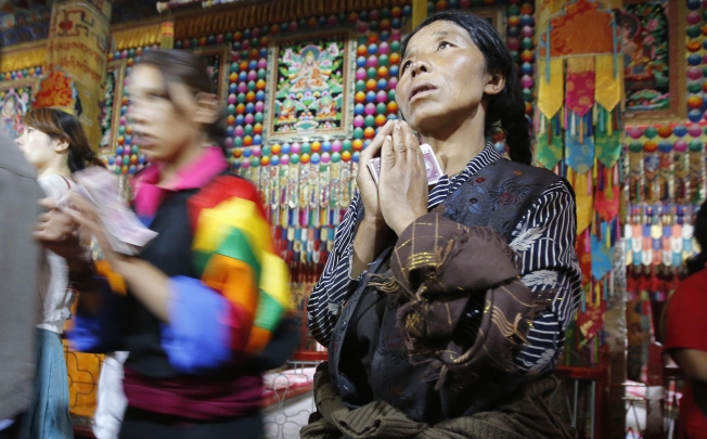 A Tibetan woman prays at Kumbum monastery, where Dalai Lama used to live, on the outskirts of Xining. Photo: Reuters