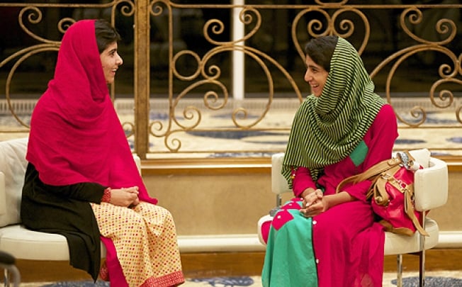 Malala Yousafzai (left) chats to schoolfriend Shazia Ramzan after being reunited at Birmingham airport, central England, on June 29. Photo: EPA