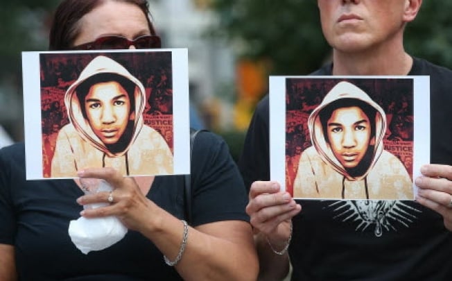 People hold photos of Trayvon Martin at a rally honoring him. Photo: AFP