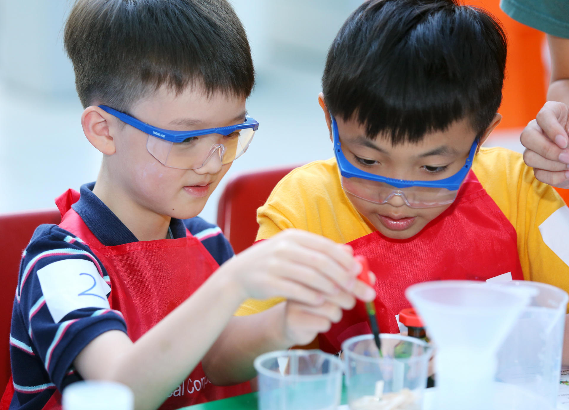 Bill Koo (left) and Herman Chan performing water purification experiments in the Kids Lab.