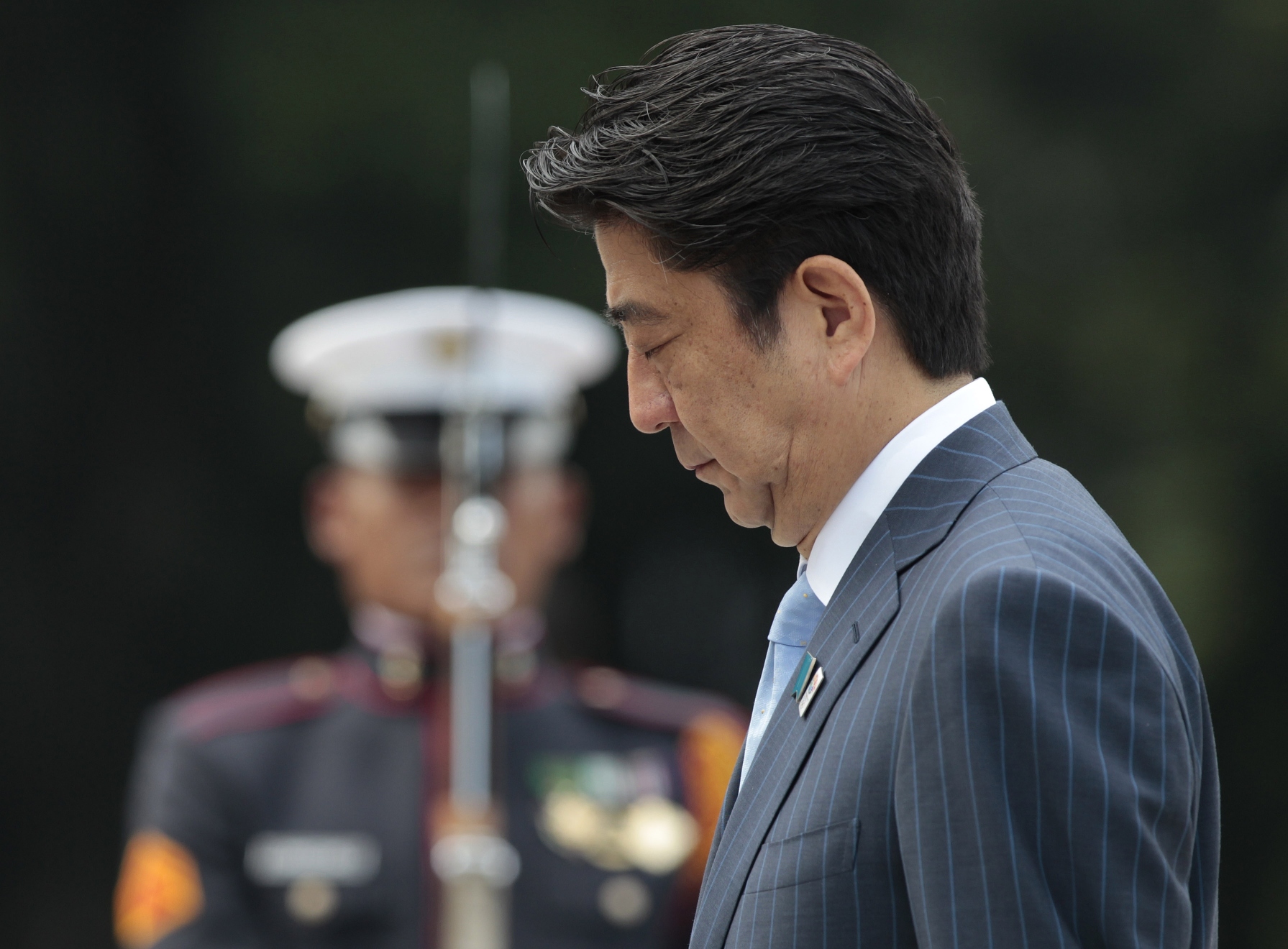 Japanese Prime Minister Shinzo Abe bows beside a Filipino honor guard during wreath laying ceremonies at the monument of Philippine National Hero Jose Rizal on Saturday. Photo: AP