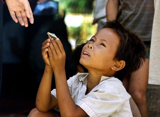 Cambodian street child accepts a small amount of change from a visitor. Photo: AP