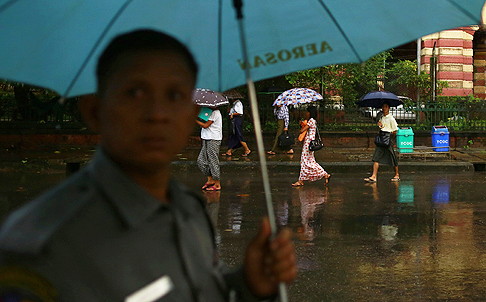 People use umbrellas as rain falls in Yangon. Photo: Reuters