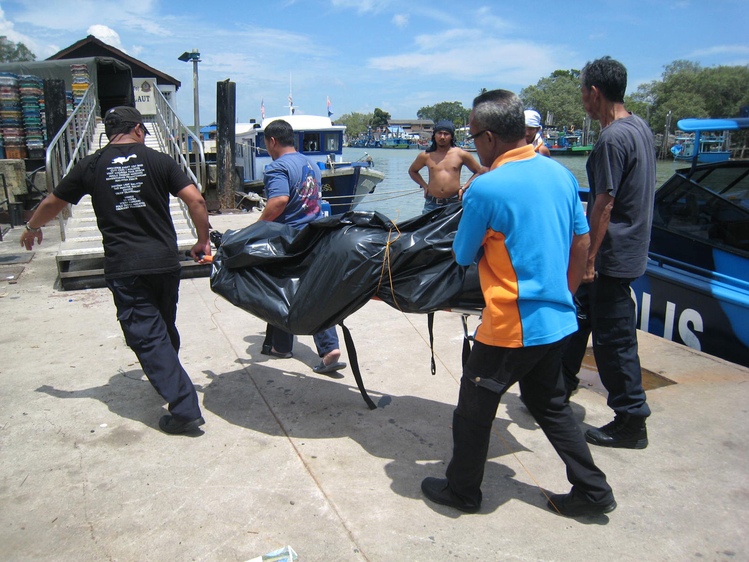 Maritime officials in Johor state transporting three victims found at sea. Photo: AFP