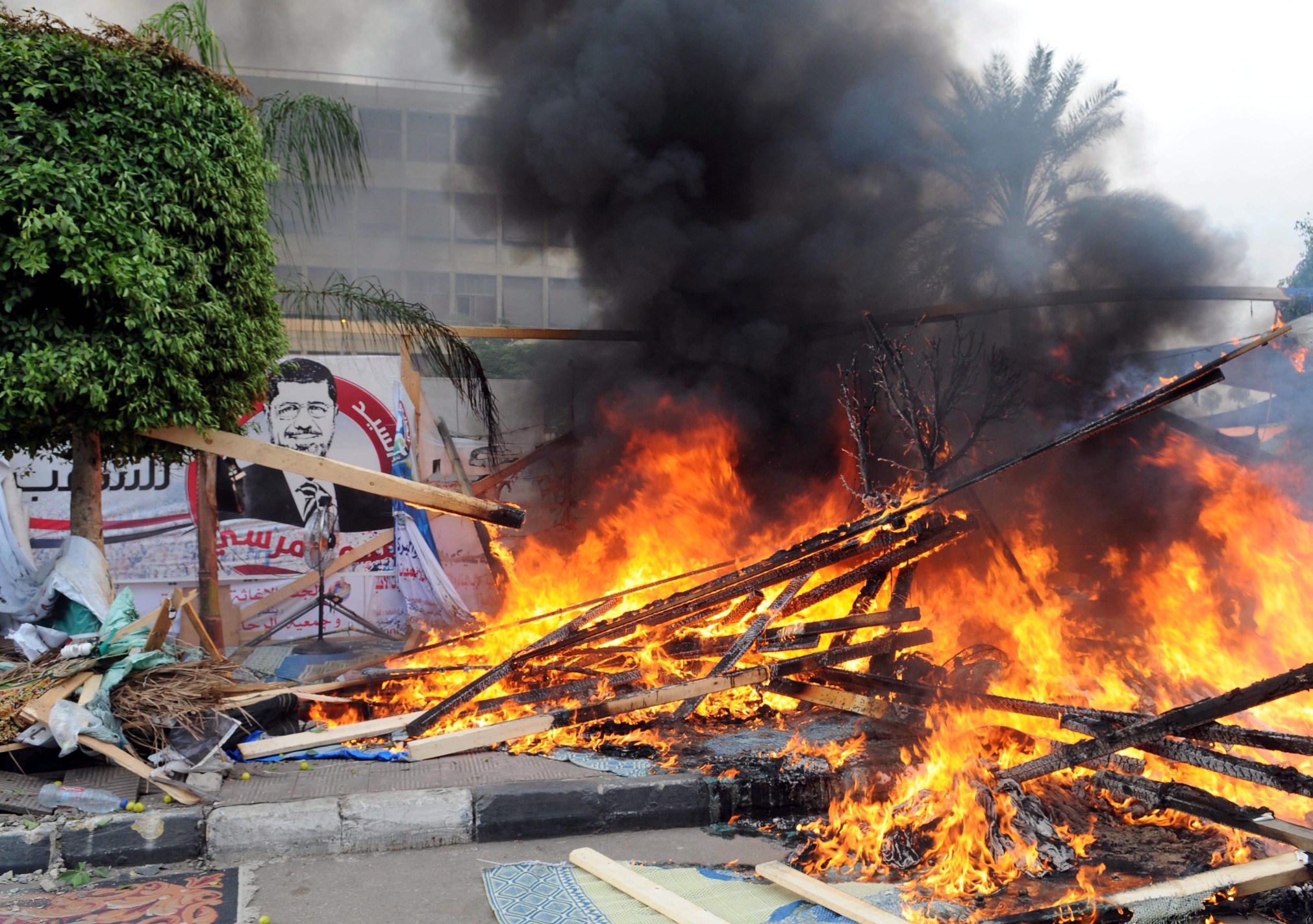 Smoke rises as a tent burns at one of the two sites of the sit-in by the Egyptians supporting ousted leader  Morsi at Nahda square near Cairo University in Cairo. Photo: EPA