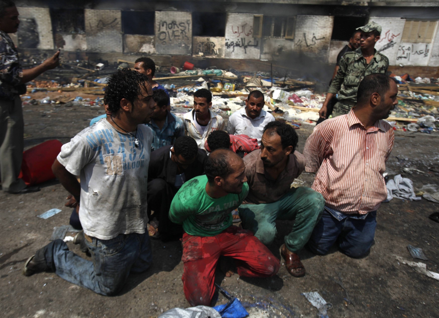Suspects are rounded up near a burnt annex building at the Rabaa Adawiya mosque in Cairo. Photo: Reuters