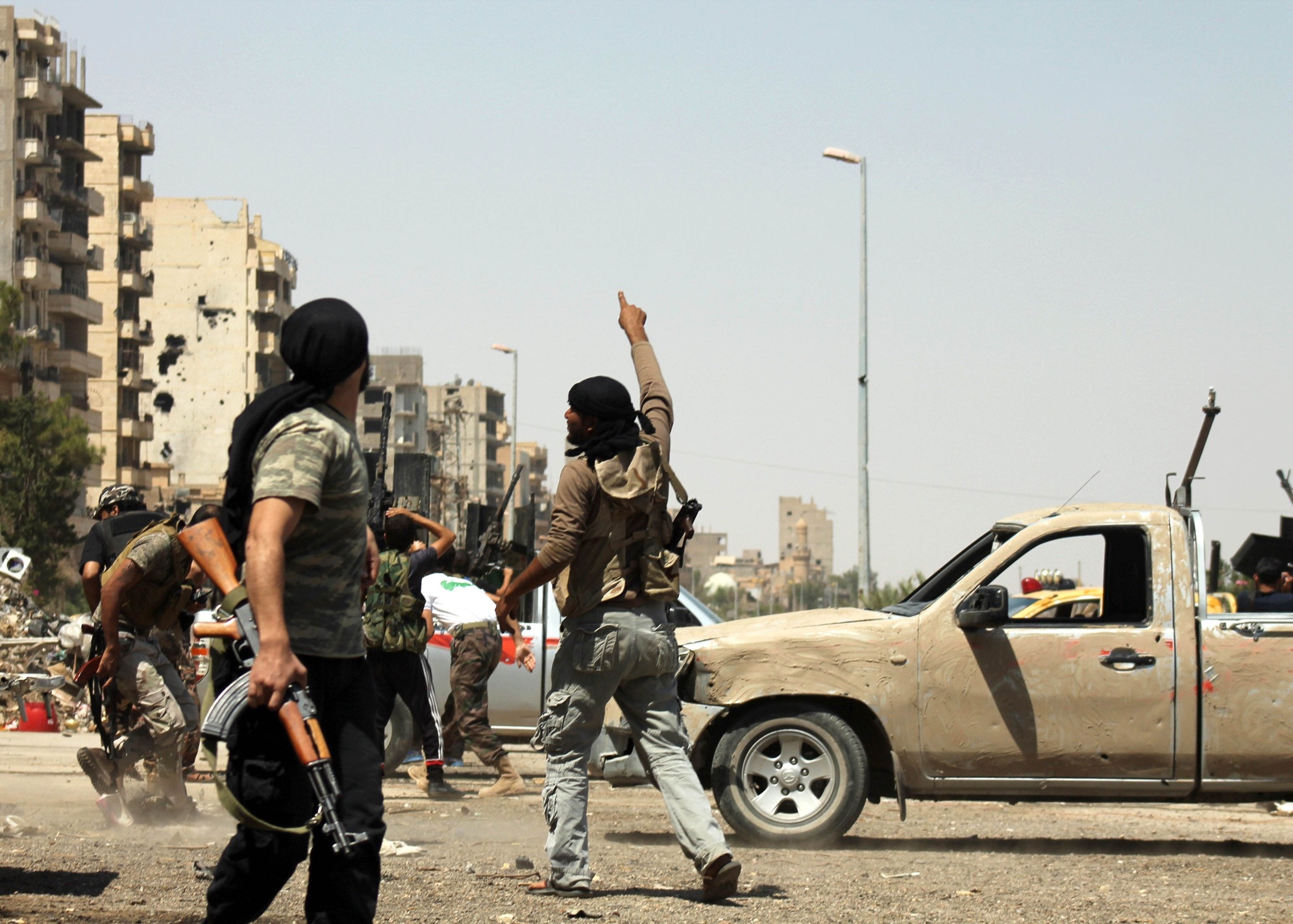 A Syrian rebel points to the sky as a regime fighter jet flies overhead in Syria's eastern town of Deir Ezzor on Saturday. Photo: AFP