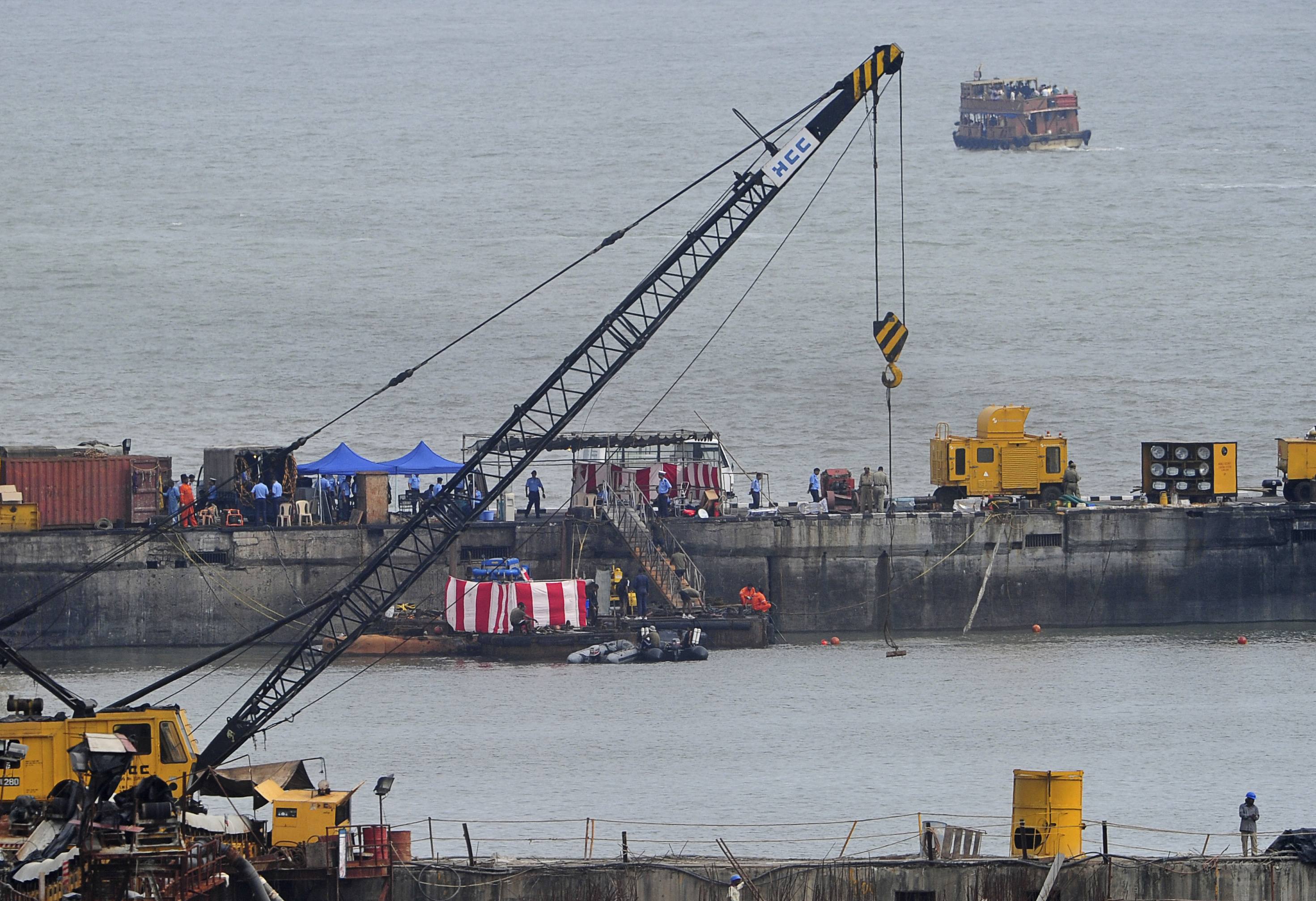 Navy divers and rescue workers stand on the INS Sindhurakshak submarine during a rescue operation. Photo: Reuters