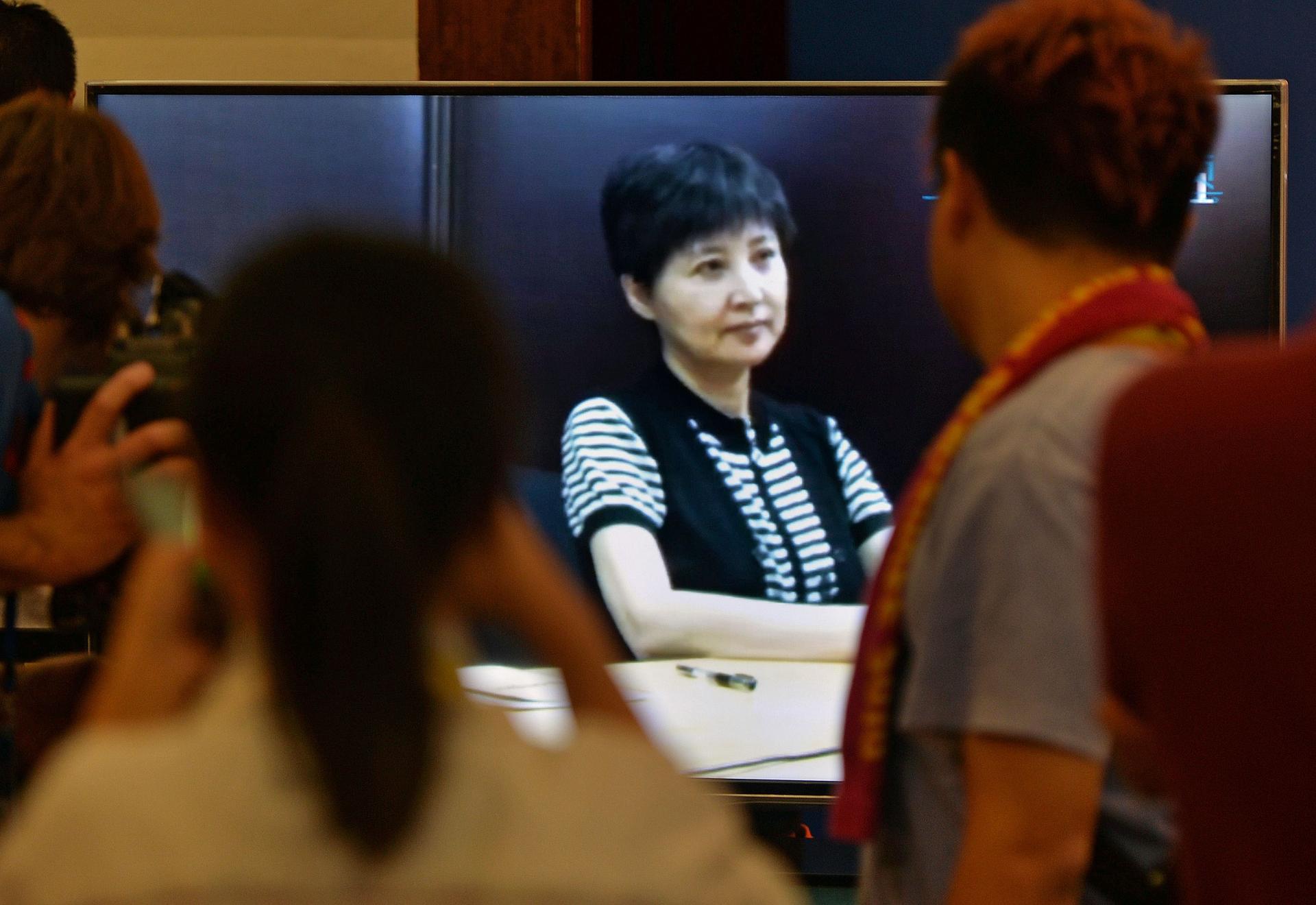 Journalists watch Gu Kailai's recorded testimony shown during Bo Xilai's trial. Photo: AFP